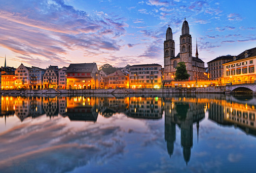 View on the river Limmat, the old town Limmatquai and the landmark Grossmünster (Great Minister) church in Zürich, Switzerland, at sunrise