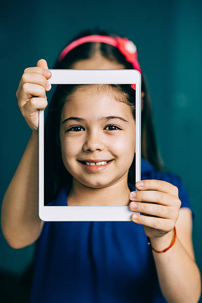 istock Smiling little girl with digital tablet making selfie 482203766