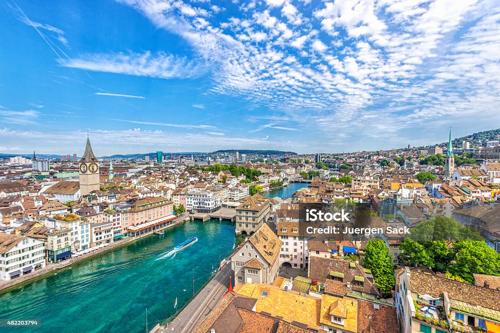 View over Zürich Elevated view over Zürich and the Limmat river with the landmark town hall and a ferry boat on a beautiful summer day. Zurich Stock Photo