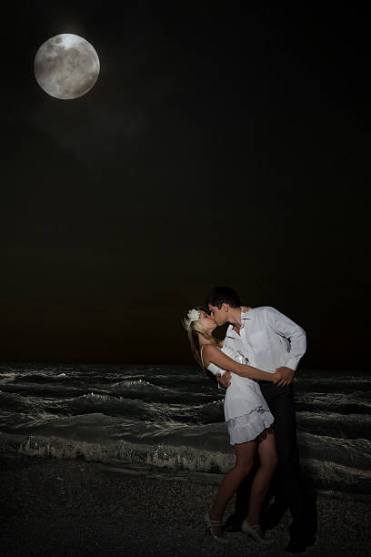 istock Couple kissing at the beach under moonlight 482208465