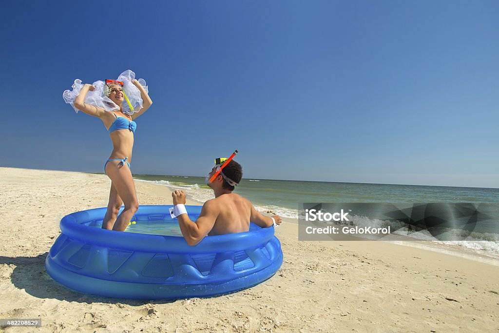 Недавно в браке пара наслаждаясь на пляже - Стоковые фото Бассейн роялти-фри