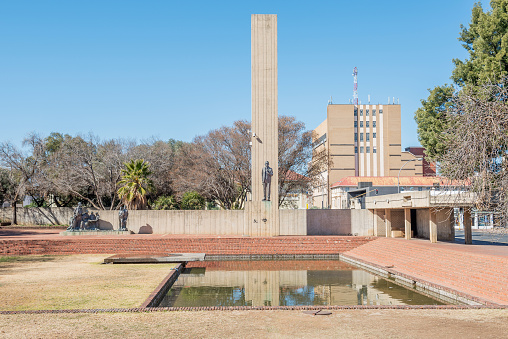 Bloemfontein, South Africa - July 19, 2015: JBM Hertzog monument in Bloemfontein with statues of General JBM Hertzog and a group of Afrikaner people during the Anglo Boer War in contrast with English boys on their right