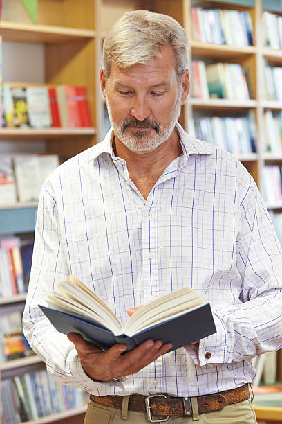 istock Male Customer Reading Book In Bookstore 482218538