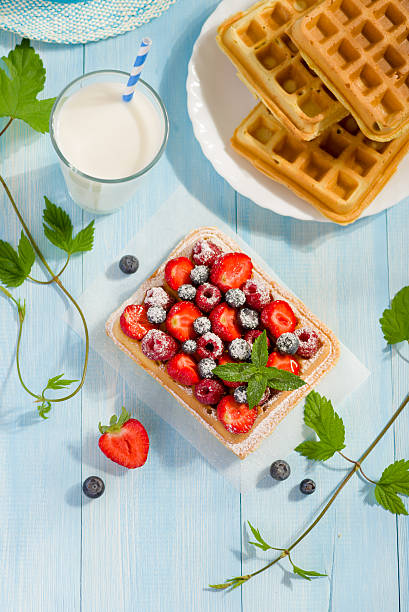 istock Waffles with strawberry and berry fruit on blue table 482227838