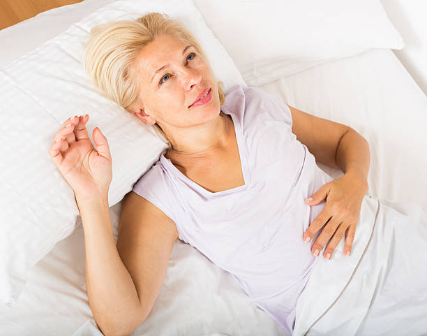 istock mature lady in shirt awaking on bed 482231426