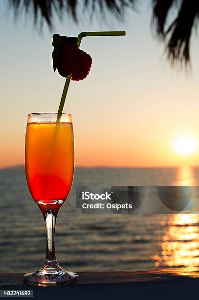 Glass With Cocktail And A Straw Against Sunset Stock Photo - Download Image Now - 2015, Alcohol - Drink, Backgrounds