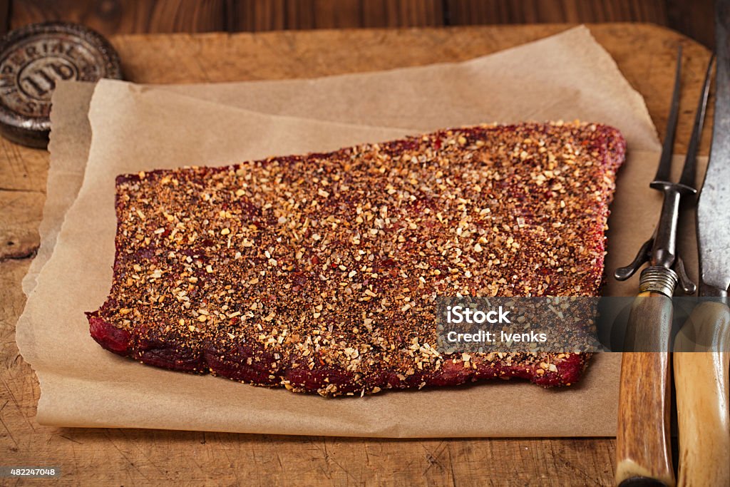 spice rubbed raw beef fillet spice rubbed raw beef fillet, making jerky meat on wooden backdrop with vintage curving fork and knife Meat Stock Photo