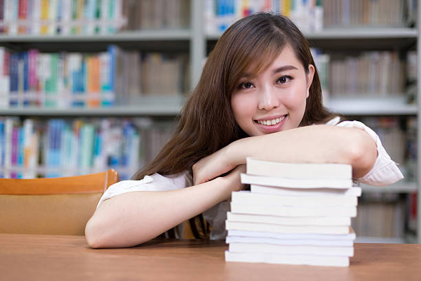 istock Beautiful asian female student read book in library 482247888