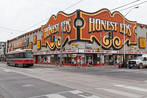 Toronto, Canada - June 22, 2015: The outside of Honest Eds in Toronto at Bloor and Bathurst Street. Traffic, people and a Streetcar can be seen.