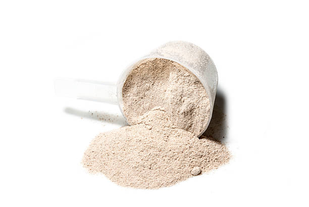 istock Scoop of Isolate protein powder chocolate deluxe flavour  poured 482260666