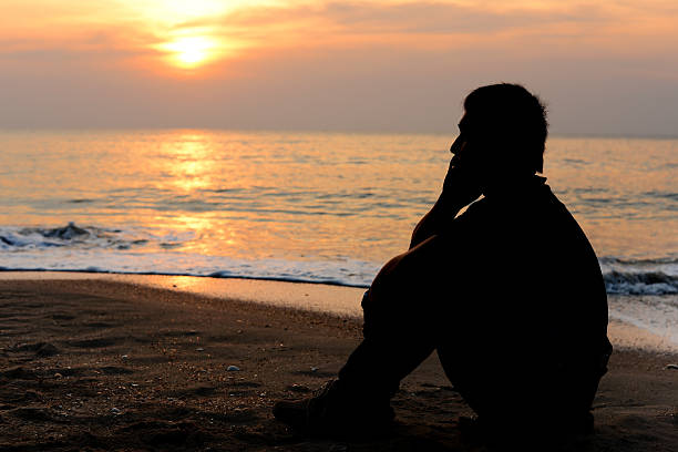istock Silhouette man sitting on the beach 482272758