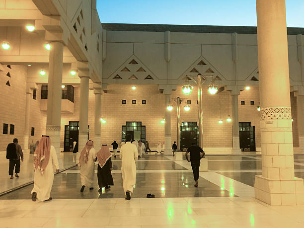 Riyadh, Saudi Arabia - February 27, 2015: Children and adults walking by Riyadh's Grand Mosque interior plaza, at sunset, heading to pray. Mobilestock image.