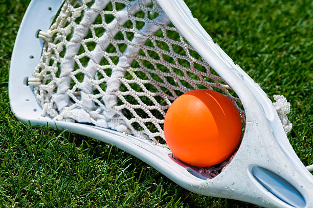 istock Orange ball and white Lacrosse stick on artificial turf 482277928