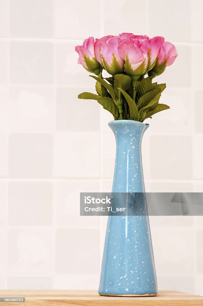 Pink rose on blue jar. fake pink rose on blue jar. Arrangement Stock Photo