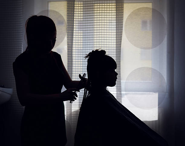 hairsalon silhouettes side view of hairdresser and little girl silhouettes in hair salon.back lit. short human hair women little girls stock pictures, royalty-free photos & images