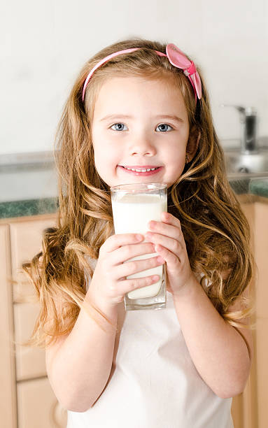 istock Beautiful smiling little girl drinking milk 482283901
