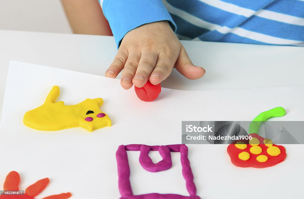 Child playing with clay molding shapes Child playing with colorful clay molding different shapes - closeup on hands Child's Play Clay Stock Photo