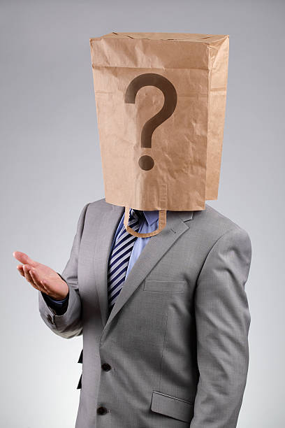Anonymous businessman with paper bag on his head Anonymous businessman wearing a paper bag on his head with a question mark concept for business recruitment, mystery shopper, failure or embarrassment anonymous businessman with paper bag on his head stock pictures, royalty-free photos & images