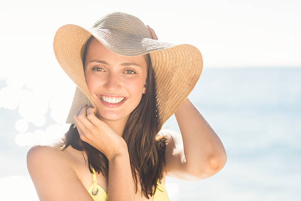 istock Brunette relaxing with a straw hat smiling at camera 482291982