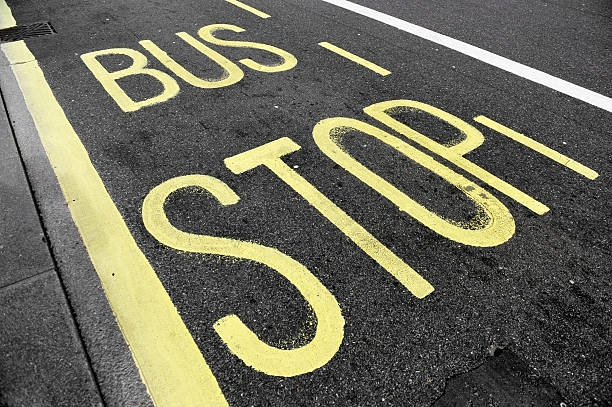 bus stop sur l'asphalte - stop mot anglais photos et images de collection