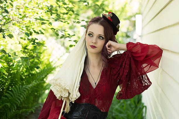 istock Young woman in steampunk outfit leaning aganst wall daydreaming. 482295042