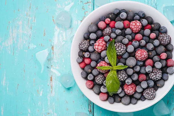 istock Frozen berries on a turquoise background with space for text 482299060