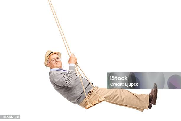 Carefree Senior Man Swinging On A Wooden Swing Stock Photo - Download Image Now - Using A Swing, Men, Senior Adult