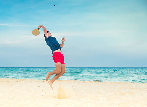 Beach paddle ball Teenager playing tennis/paddle ball in the beach paddle ball stock pictures, royalty-free photos & images