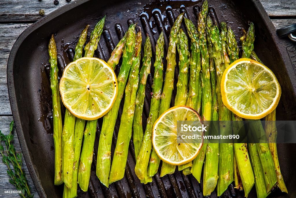 grilled organic asparagus with lemon grilled organic asparagus with lemon in a frying pan Asparagus Stock Photo