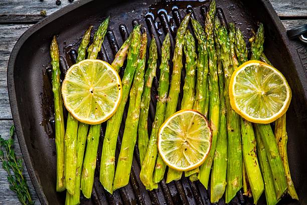 grilled organic asparagus with lemon grilled organic asparagus with lemon in a frying pan asparagus stock pictures, royalty-free photos & images