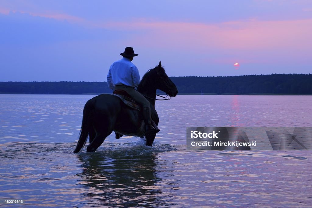 Rider on a horse наблюдать Восход солнца - Стоковые фото Ковбой роялти-фри