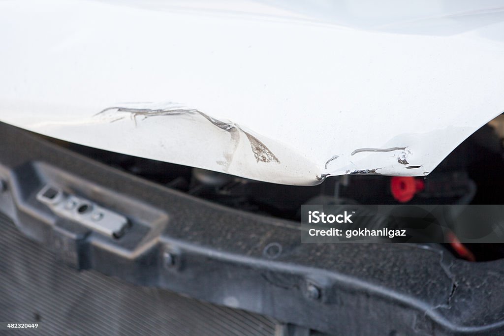 White car after accident. The crumpled front end of a white car after an accident. Aircraft Wing Stock Photo