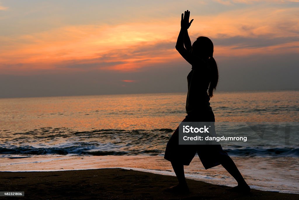 Silhouette woman Yoga on the beach Silhouette woman Yoga on the beach  Active Lifestyle Stock Photo