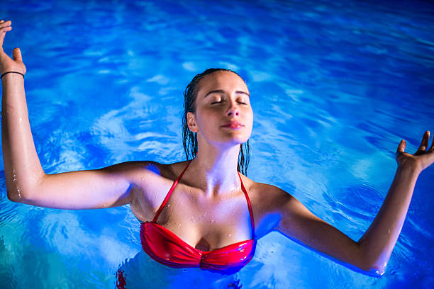 istock young woman on the pool at night 482328680