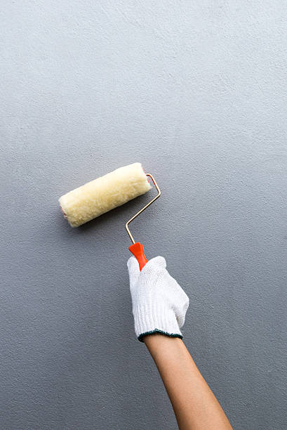 hand glove holding paint brush stock photo