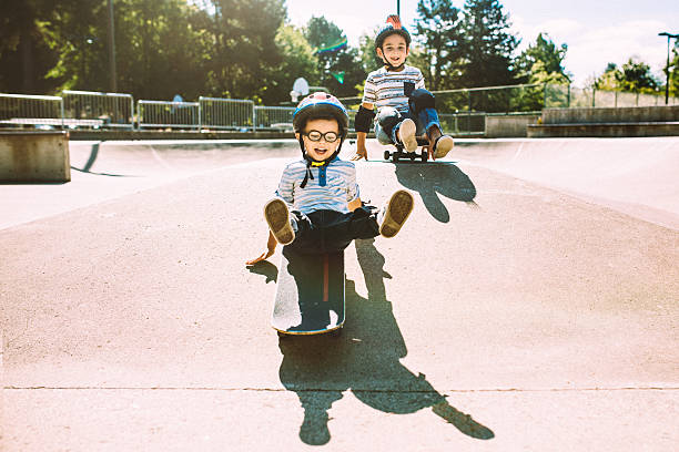 istock Brothers Riding Skateboards at Park 482330576