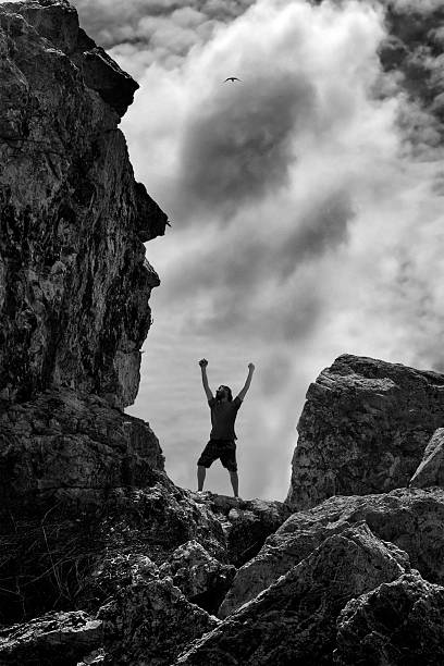 istock Man in the mountains with his two hands raised up 482333714