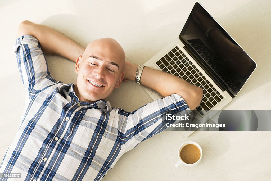 Having break Above view of a businessman resting on the floor with smile after exhausted working day Above Stock Photo