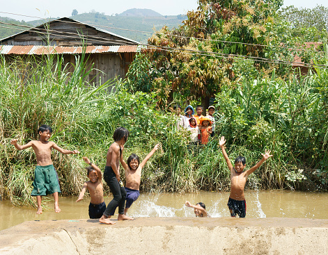Lam Dong, Viet Nam - February 24, 2015: Group of Unidentified Asian children have fun at Vietnamese countryside, crowd of boy, girl bath in the river, kid jump to water, danger for child, Vietnam, Feb24, 2015