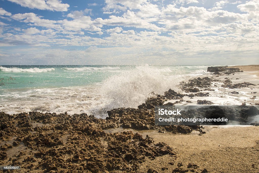Rock Formation On Hutchinson Island Waves crashing on to the asastasia formation on the beach of this beautiful island.  The sky if full of white clouds filled in with a clear blue sky. Island Stock Photo