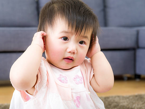 bambina con la mano all'orecchio di copertina - korea child baby asian culture foto e immagini stock