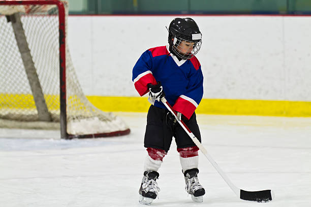 istock Child skating with a puck at ice hockey practice 482341409