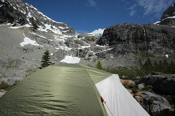 istock Camping in a tent under a snow covered mountain peek 482343214