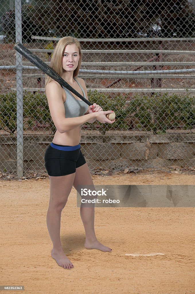 Woman Baseball Player Beautiful woman hitting a baseball with a bat Activity Stock Photo