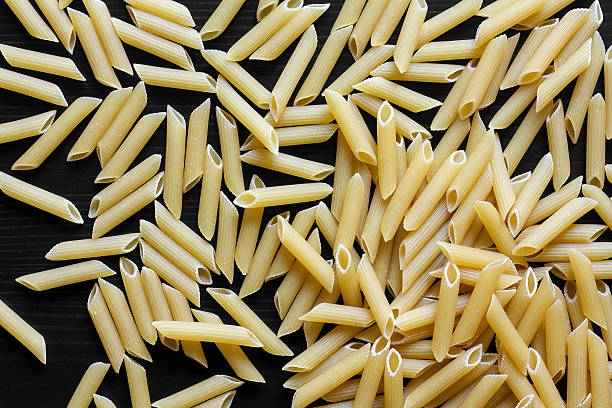 istock Dry pasta on black textured wood from above. 482355884