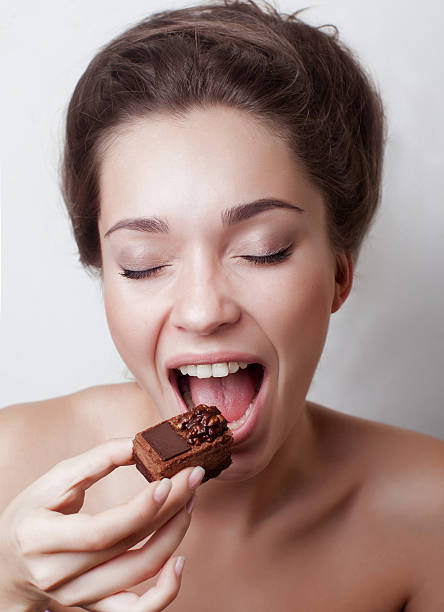 istock luxury funny beautiful young lady eating candy 482357198