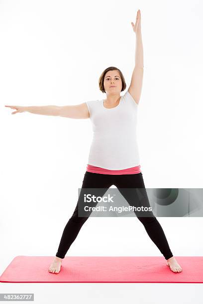 Photo libre de droit de Femme Enceinte En Pratiquant Le Yoga banque d'images et plus d'images libres de droit de Adulte - Adulte, Bien-être, Bonne posture