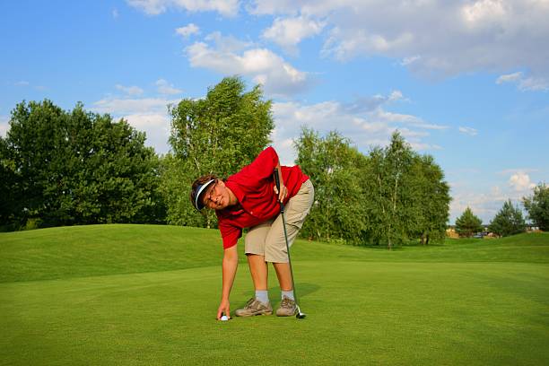 golf, frau golfer genießen einen ball von der loch - golf golf course putting green hole stock-fotos und bilder