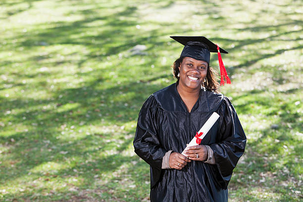 Masters degree Mature African American woman (40s) in graduation cap and gown. Master’s Degree stock pictures, royalty-free photos & images