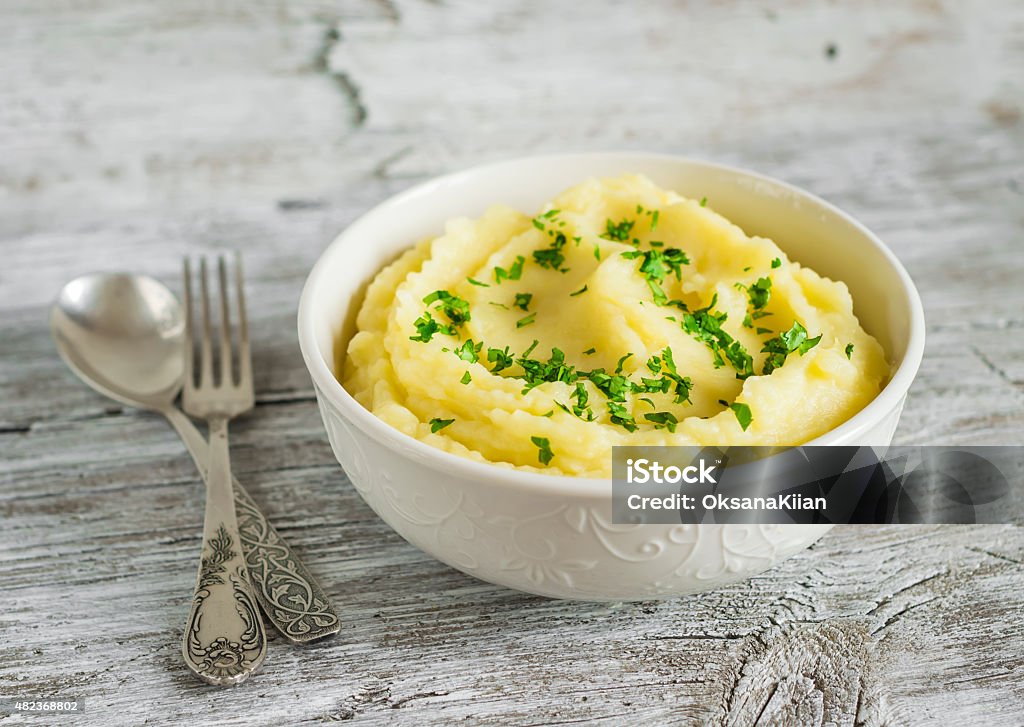 mashed potatoes in a white bowl on a light wooden background Mashed Potatoes Stock Photo